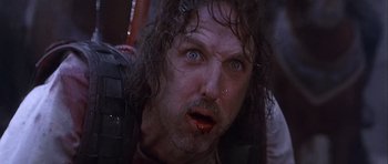 Movie still from “Flesh+Blood” (1985), directed by Paul Verhoeven – A person with long hair and blue eyes; Close Up shot, Low angle