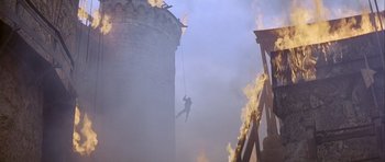 Movie still from “Flesh+Blood” (1985), directed by Paul Verhoeven – A man on a rope attached to a building; Extreme Wide shot, Low angle