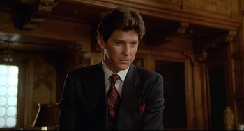 Movie still from “Fletch” (1985), directed by Michael Ritchie – A person wearing a suit and tie; Close Up shot, Low angle