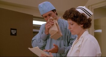 Movie still from “Fletch” (1985), directed by Michael Ritchie – A doctor and a nurse looking at a paper bag; Close Up shot, Low angle
