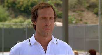 Movie still from “Fletch” (1985), directed by Michael Ritchie – A person wearing a white shirt; Close Up shot, Over the shoulder angle