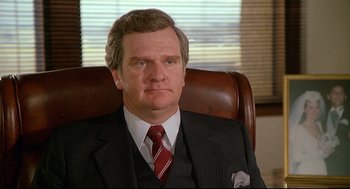 Movie still from “Fletch” (1985), directed by Michael Ritchie – A person wearing a suit and tie; Close Up shot, Low angle
