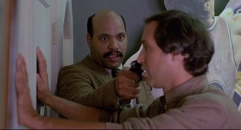 Movie still from “Fletch” (1985), directed by Michael Ritchie – A man is shaving his face in front of a mirror; Close Up shot, Over the shoulder angle
