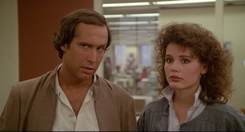 Movie still from “Fletch” (1985), directed by Michael Ritchie – A man and a woman standing next to each other; Close Up shot, Over the shoulder angle