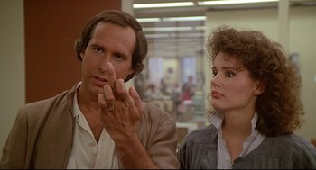 Movie still from “Fletch” (1985), directed by Michael Ritchie – A man and a woman are looking at each other; Close Up shot, Over the shoulder angle