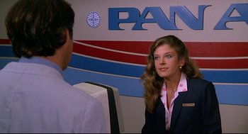 Movie still from “Fletch” (1985), directed by Michael Ritchie – A man and a woman in front of a pan am sign; Medium shot, Low angle