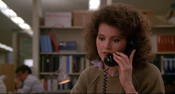 Movie still from “Fletch” (1985), directed by Michael Ritchie – A woman talking on a phone while wearing a sweater; Close Up shot, Low angle