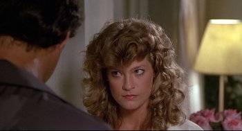 Movie still from “Fletch” (1985), directed by Michael Ritchie – A person wearing a wig; Close Up shot, Over the shoulder angle