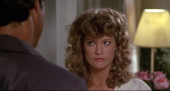 Movie still from “Fletch” (1985), directed by Michael Ritchie – A person with a person looking at the camera; Close Up shot, Over the shoulder angle