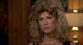 Movie still from “Fletch” (1985), directed by Michael Ritchie – A person wearing a necklace; Close Up shot, Over the shoulder angle