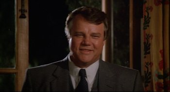 Movie still from “Fletch” (1985), directed by Michael Ritchie – A person wearing a suit and tie; Close Up shot, Low angle