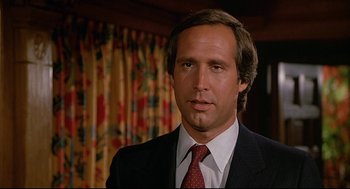 Movie still from “Fletch” (1985), directed by Michael Ritchie – A person wearing a suit and tie; Close Up shot, Low angle
