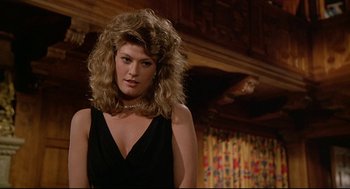 Movie still from “Fletch” (1985), directed by Michael Ritchie – A woman in a black dress with long blonde hair; Close Up shot, Over the shoulder angle