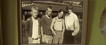 Movie still from “Flickering Lights” (2000), directed by Anders Thomas Jensen – A black and white photo of a group of young men and a woman; Medium shot, Low angle