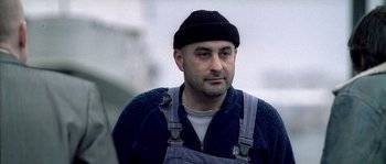 Movie still from “Flickering Lights” (2000), directed by Anders Thomas Jensen – A person wearing a hat; Close Up shot, Low angle