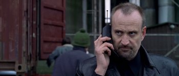 Movie still from “Flickering Lights” (2000), directed by Anders Thomas Jensen – A man is talking on a cell phone; Close Up shot, Low angle