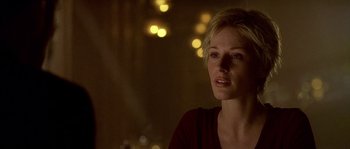 Movie still from “Flickering Lights” (2000), directed by Anders Thomas Jensen – A woman in a red shirt is looking into the distance; Close Up shot, Over the shoulder angle