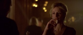 Movie still from “Flickering Lights” (2000), directed by Anders Thomas Jensen – A woman holding a glass of wine in her hand; Close Up shot, Over the shoulder angle