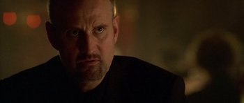 Movie still from “Flickering Lights” (2000), directed by Anders Thomas Jensen – A person with a black shirt; Close Up shot, Low angle