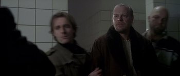 Movie still from “Flickering Lights” (2000), directed by Anders Thomas Jensen – Two men standing next to each other in a room; Close Up shot, Over the shoulder angle