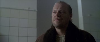 Movie still from “Flickering Lights” (2000), directed by Anders Thomas Jensen – An older man with a beard and a brown jacket looking up; Close Up shot, Over the shoulder angle