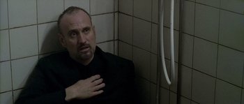 Movie still from “Flickering Lights” (2000), directed by Anders Thomas Jensen – A man in a black shirt is standing in a bathroom; Close Up shot, Low angle