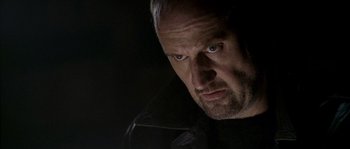 Movie still from “Flickering Lights” (2000), directed by Anders Thomas Jensen – A person wearing a black jacket; Close Up shot, Low angle