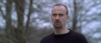 Movie still from “Flickering Lights” (2000), directed by Anders Thomas Jensen – A person wearing a sweater; Close Up shot, Low angle