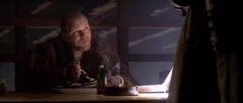 Movie still from “Flickering Lights” (2000), directed by Anders Thomas Jensen – A man sitting in front of a computer at a table; Close Up shot, Over the shoulder angle