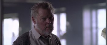 Movie still from “Flickering Lights” (2000), directed by Anders Thomas Jensen – An older man with a beard and a tie; Close Up shot, Low angle