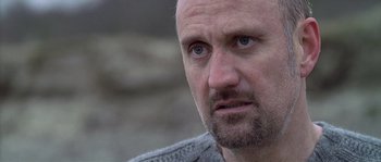 Movie still from “Flickering Lights” (2000), directed by Anders Thomas Jensen – A person with a beard; Close Up shot, Low angle