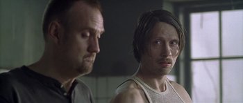 Movie still from “Flickering Lights” (2000), directed by Anders Thomas Jensen – Two men standing next to each other in a room; Close Up shot, Over the shoulder angle