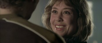Movie still from “Flickering Lights” (2000), directed by Anders Thomas Jensen – A woman smiling at the camera; Close Up shot, Over the shoulder angle