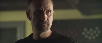 Movie still from “Flickering Lights” (2000), directed by Anders Thomas Jensen – A person looking at the camera; Close Up shot, Low angle