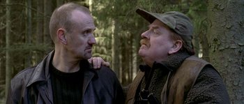 Movie still from “Flickering Lights” (2000), directed by Anders Thomas Jensen – Two men in the woods talking to each other; Close Up shot, Over the shoulder angle