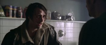 Movie still from “Flickering Lights” (2000), directed by Anders Thomas Jensen – A man with long black hair wearing a leather jacket; Close Up shot, Over the shoulder angle
