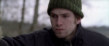 Movie still from “Flickering Lights” (2000), directed by Anders Thomas Jensen – A person wearing a hat; Close Up shot, Low angle