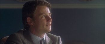 Movie still from “Flickering Lights” (2000), directed by Anders Thomas Jensen – A person wearing a suit and tie; Close Up shot, Low angle