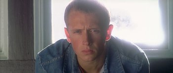 Movie still from “Flickering Lights” (2000), directed by Anders Thomas Jensen – A person wearing a jean jacket; Close Up shot, Low angle