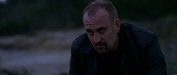 Movie still from “Flickering Lights” (2000), directed by Anders Thomas Jensen – A person wearing a black jacket; Close Up shot, Low angle