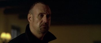 Movie still from “Flickering Lights” (2000), directed by Anders Thomas Jensen – A person wearing a black shirt; Close Up shot, Low angle