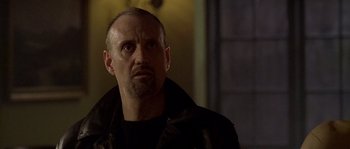 Movie still from “Flickering Lights” (2000), directed by Anders Thomas Jensen – A man in a leather jacket looking to his left; Close Up shot, Low angle