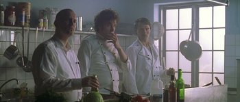 Movie still from “Flickering Lights” (2000), directed by Anders Thomas Jensen – A group of chefs standing in a kitchen preparing food; Medium shot, Low angle