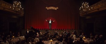 Movie still from “Florence Foster Jenkins” (2016), directed by Stephen Frears – A man standing on a stage in front of an audience; Extreme Wide shot, Low angle