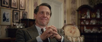 Movie still from “Florence Foster Jenkins” (2016), directed by Stephen Frears – A man sitting in a chair with his hands clasped together; Close Up shot, Low angle