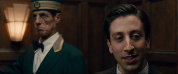 Movie still from “Florence Foster Jenkins” (2016), directed by Stephen Frears – A man in a suit standing next to another man in a suit; Close Up shot, Over the shoulder angle