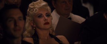 Movie still from “Florence Foster Jenkins” (2016), directed by Stephen Frears – A woman with blonde hair and red lipstick looking to her left; Close Up shot, Over the shoulder angle