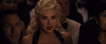 A woman with blonde hair and blue eyes wearing a black dress