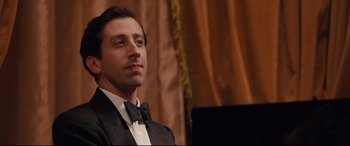 Movie still from “Florence Foster Jenkins” (2016), directed by Stephen Frears – A person wearing a suit and bow tie; Close Up shot, Low angle