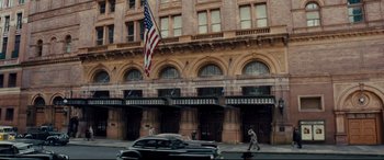 Movie still from “Florence Foster Jenkins” (2016), directed by Stephen Frears – An american flag is flying in front of a building; Extreme Wide shot, Low angle